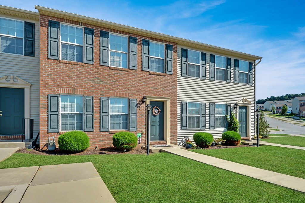 a brick apartment building with a sidewalk in front of it