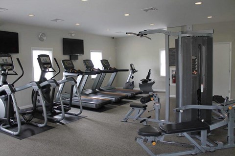 a gym with a lot of machines and weights