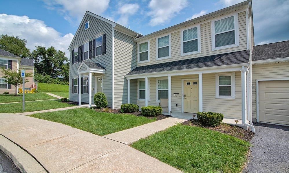 a two story house with a sidewalk in front of it