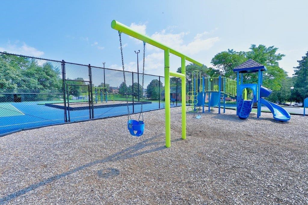 a playground with a swing set and a basketball court