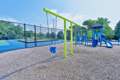 a playground with a swing set and a basketball court