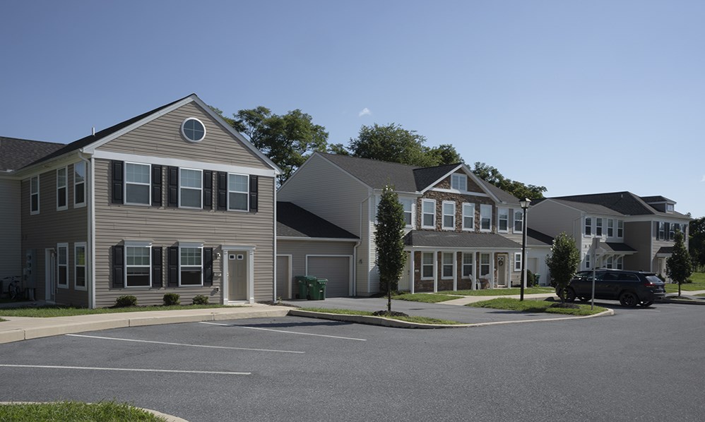 a row of houses on a street with a car parked in front