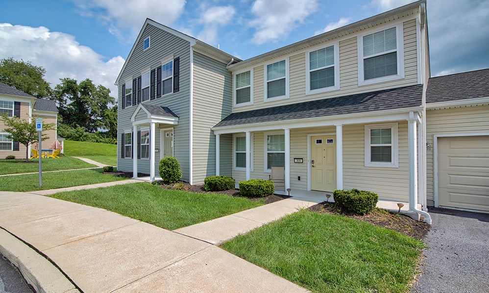 a two story house with a sidewalk in front of it