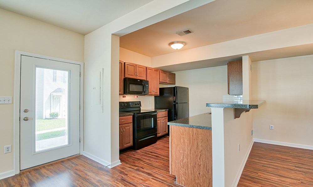 an empty kitchen with a door to the living room