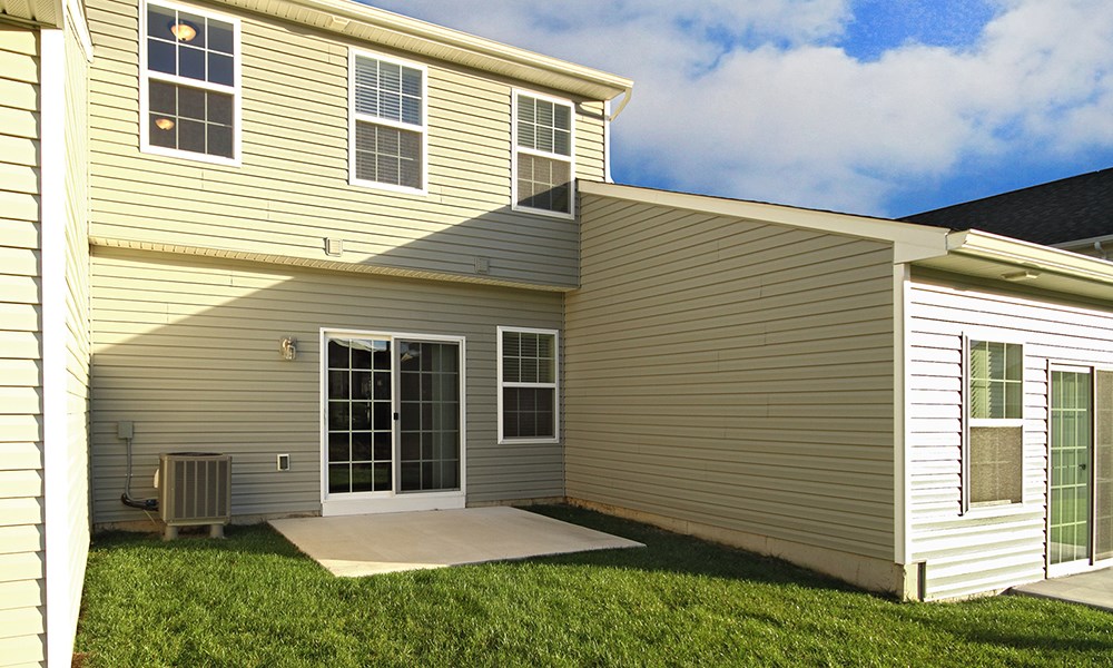 the back of a house with a patio and grass