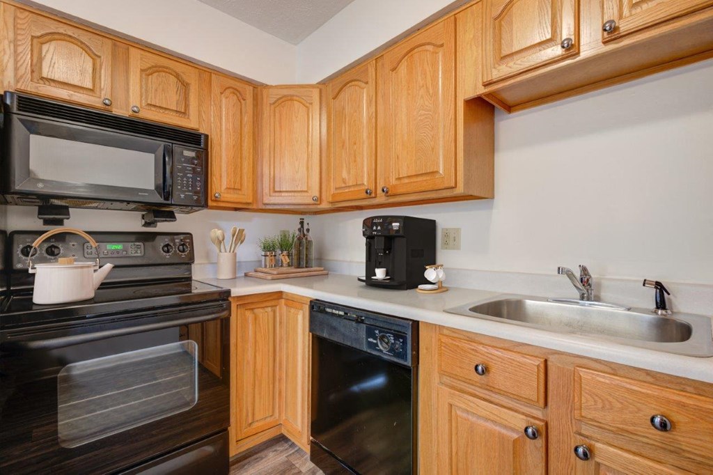a kitchen with black appliances and wooden cabinets