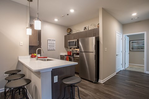 a kitchen with a counter top and a stainless steel refrigerator