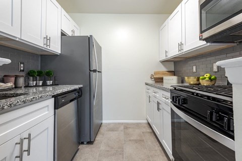 a kitchen with stainless steel appliances and white cabinets
