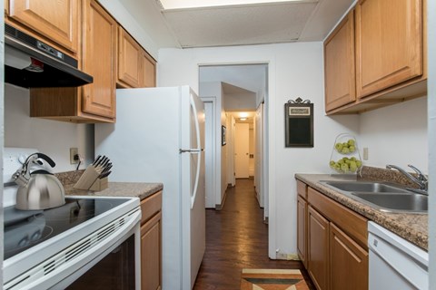 A kitchen with wooden cabinets and a white refrigerator.
