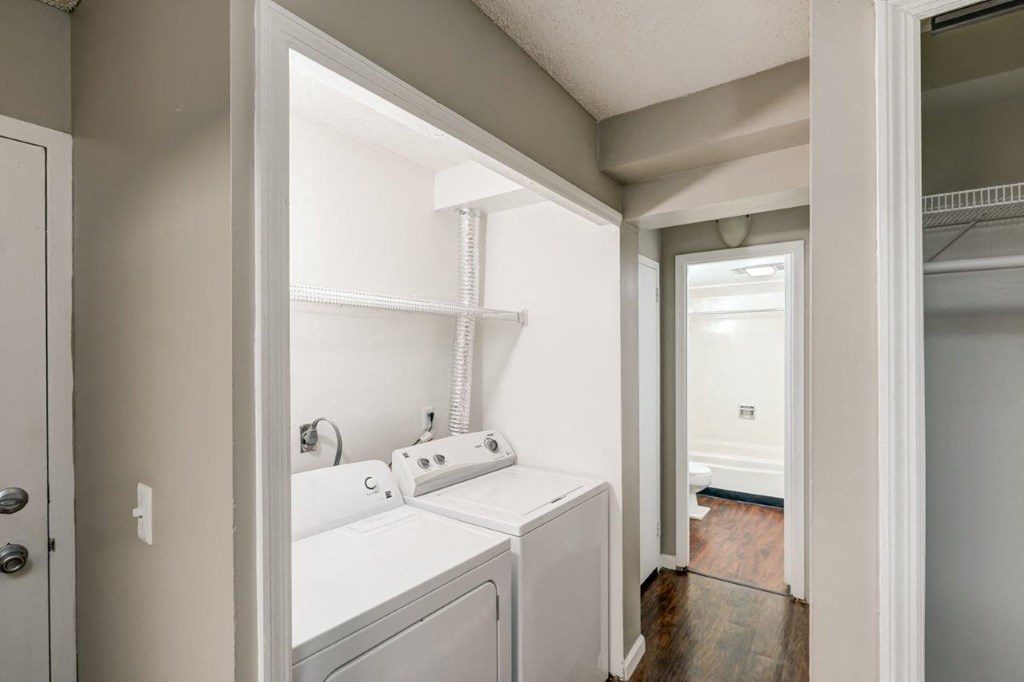 a white laundry room with two washes and a dryer