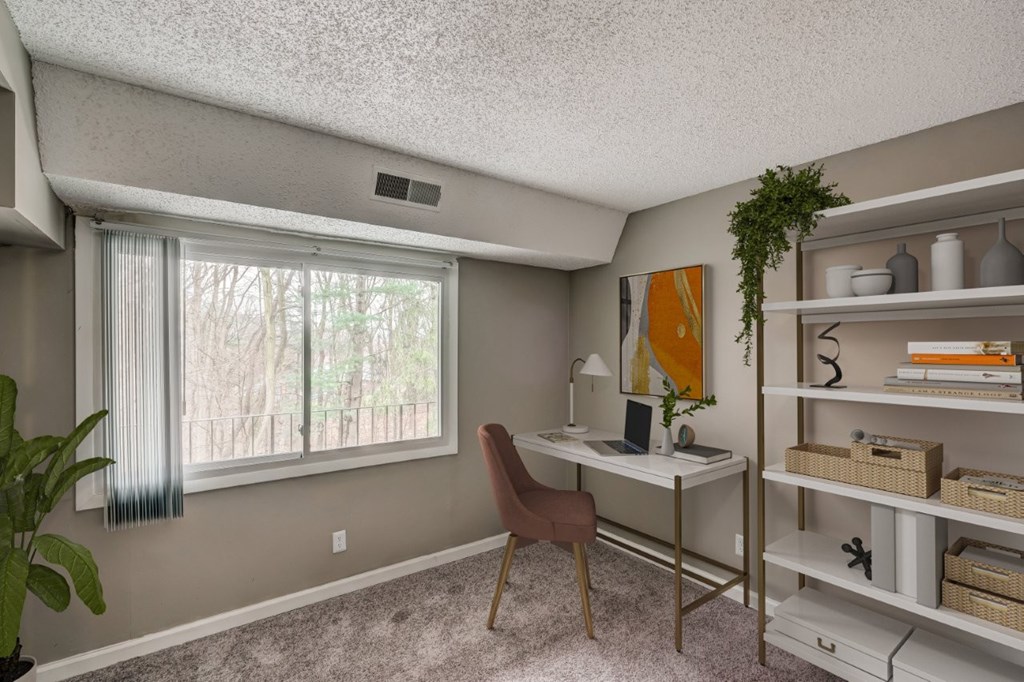 a home office with a desk and a window