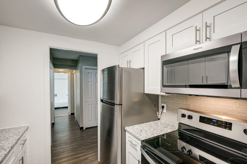 a kitchen with stainless steel appliances and white cabinets
