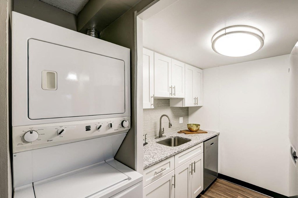 a white kitchen with a sink and a refrigerator