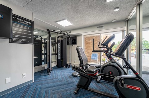 A fitness center with a treadmill and a sign on the wall.