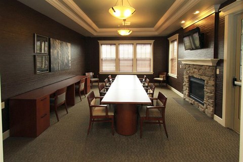 A conference room with a long table and chairs.