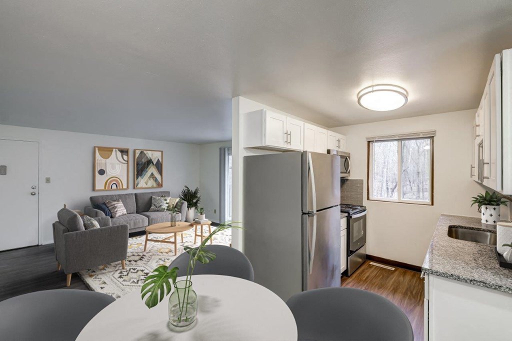 a kitchen and living room with a refrigerator and a table