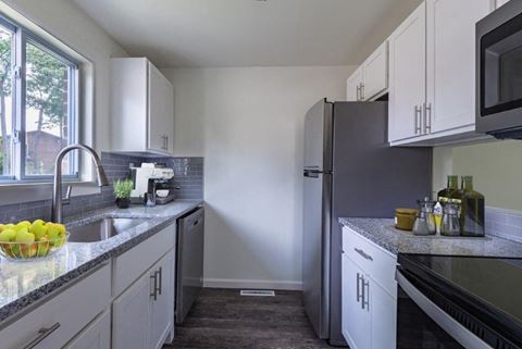 a kitchen with white cabinets and a stainless steel refrigerator