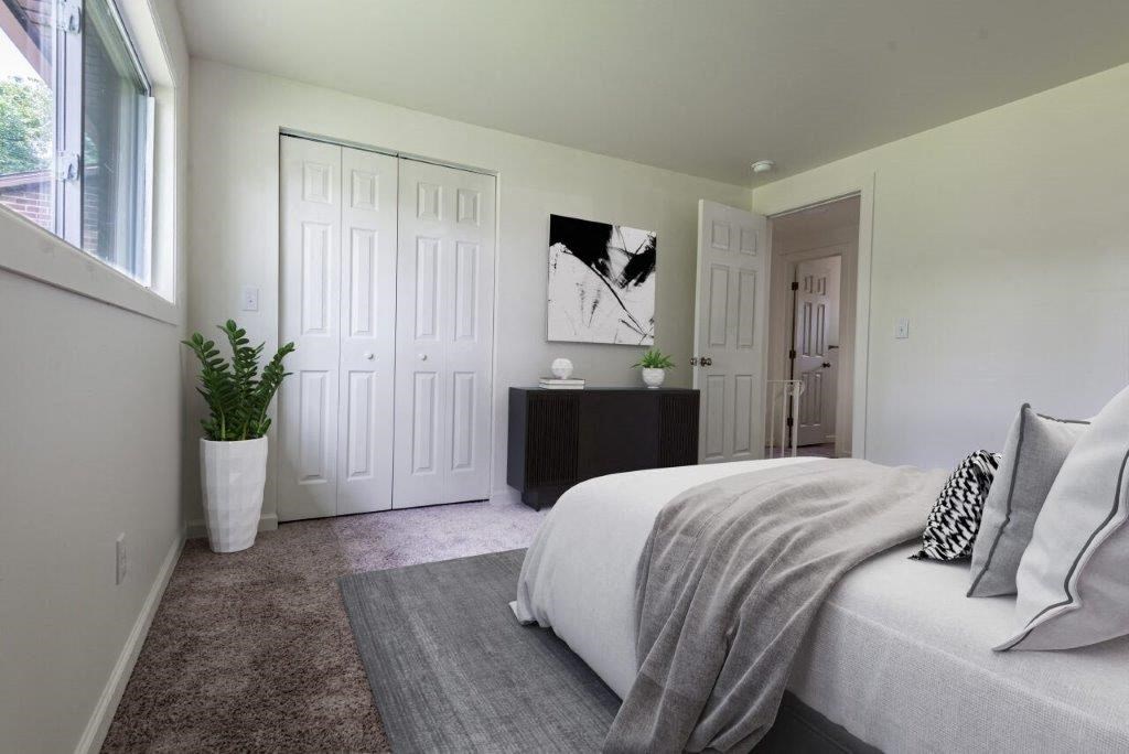 a bedroom with a bed and a potted plant