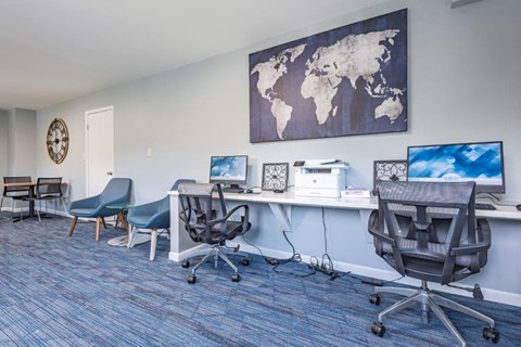 a office with a desk with two computers and a map on the wall