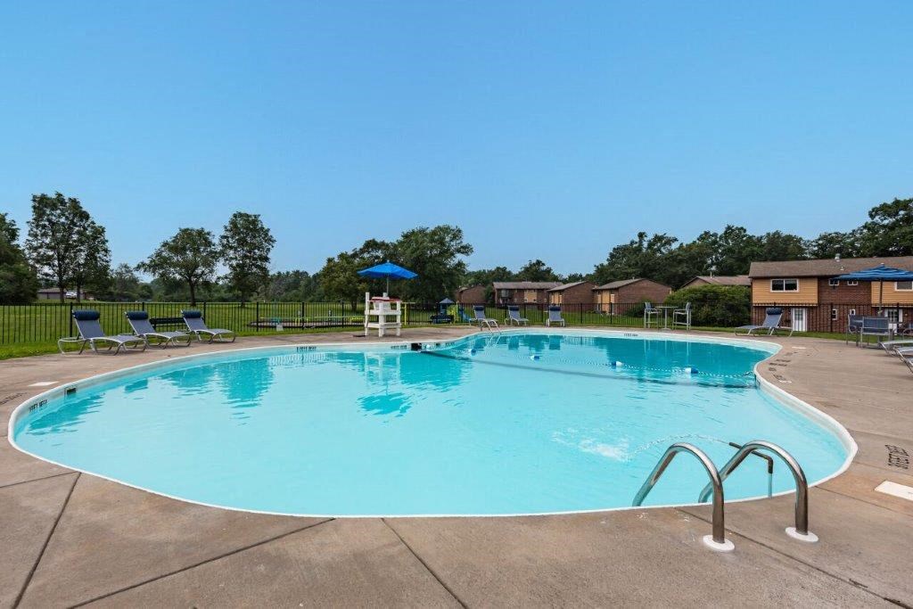 a large swimming pool with chairs around it