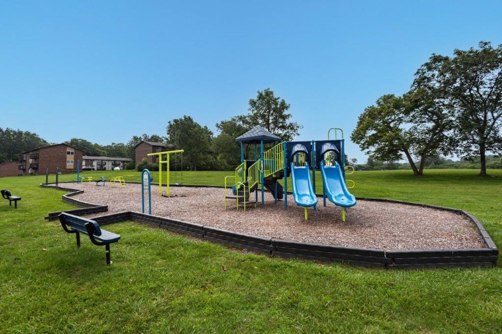 a playground with a swing set in a park