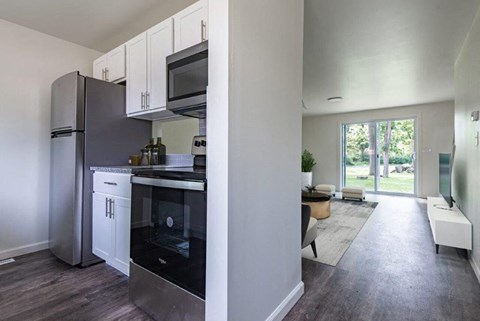a kitchen and living room with a stove and refrigerator