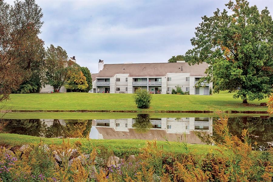 a large building with a pond in front of it