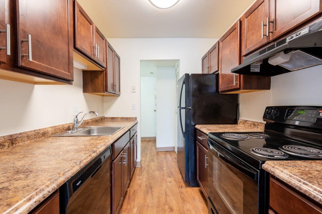 a kitchen with wooden cabinets and black appliances