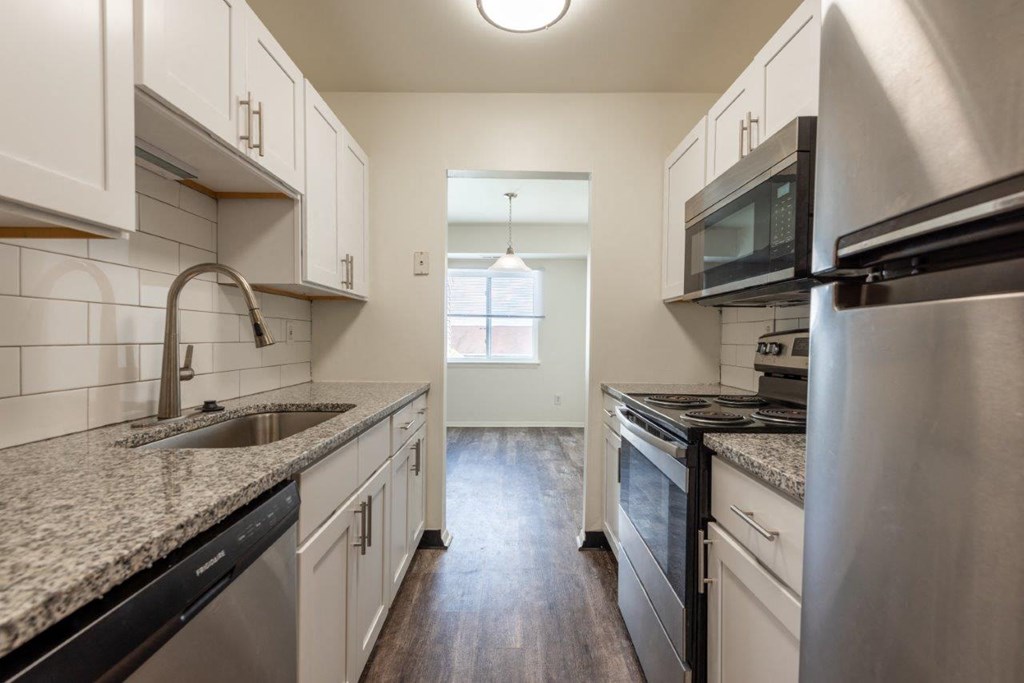 a kitchen with granite counter tops and stainless steel appliances