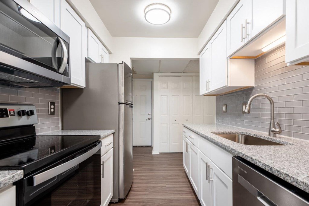 a kitchen with marble counter tops and white cabinets