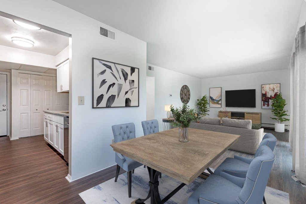 a dining room table with blue chairs and a living room