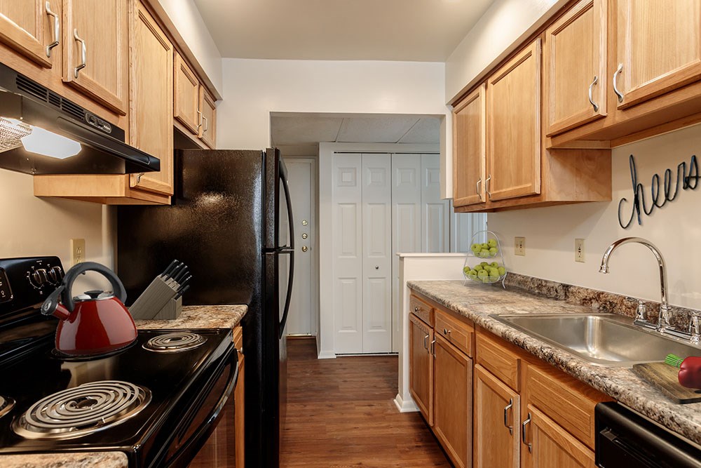 a kitchen with black appliances and wooden cabinets