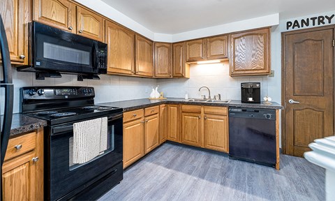 a kitchen with black appliances and wooden cabinets