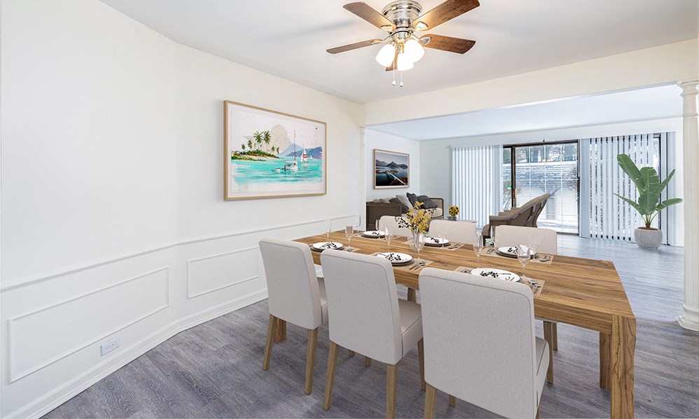 a dining room with a wooden table and chairs and a ceiling fan