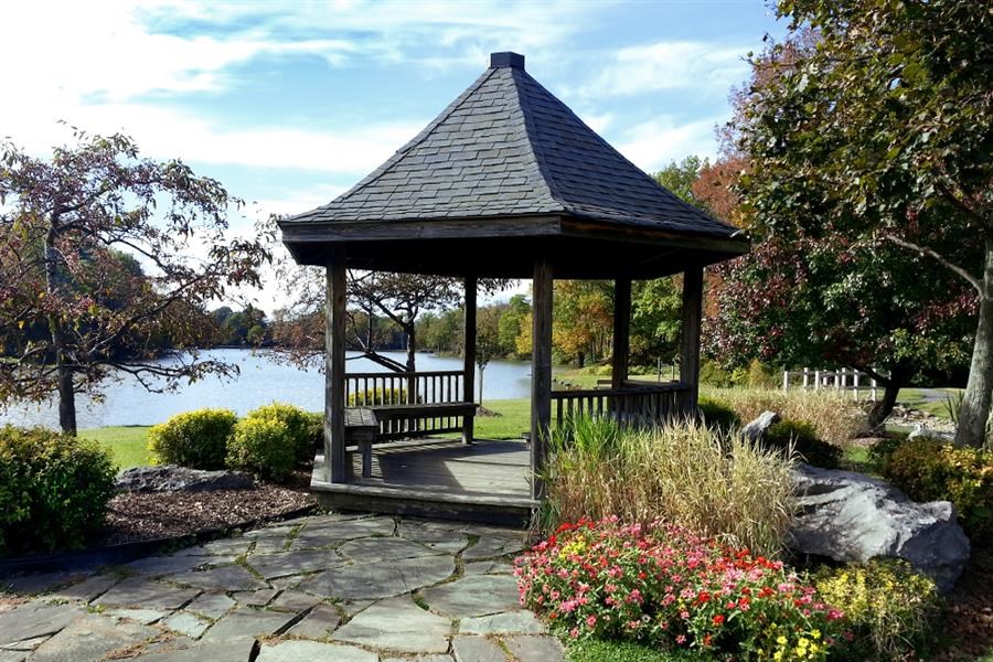 a gazebo with a bench next to a lake