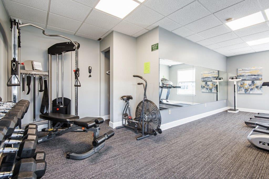 a home gym with weights and cardio equipment on the wall