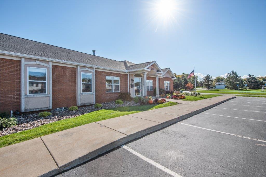 a sidewalk in front of a brick building with a flag