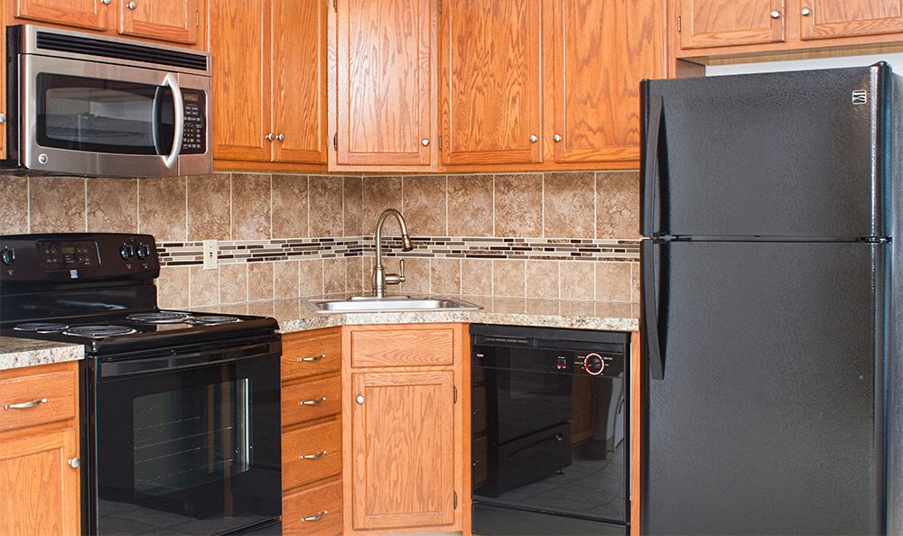 a kitchen with black appliances and wood cabinets
