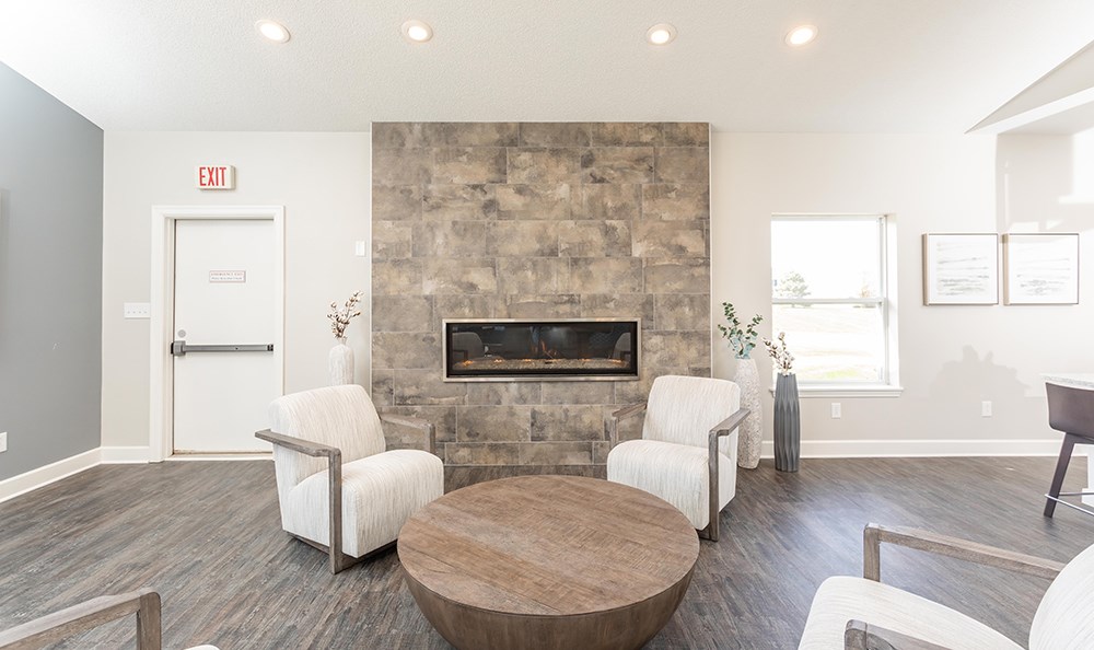 a living room with a fireplace and a table and chairs