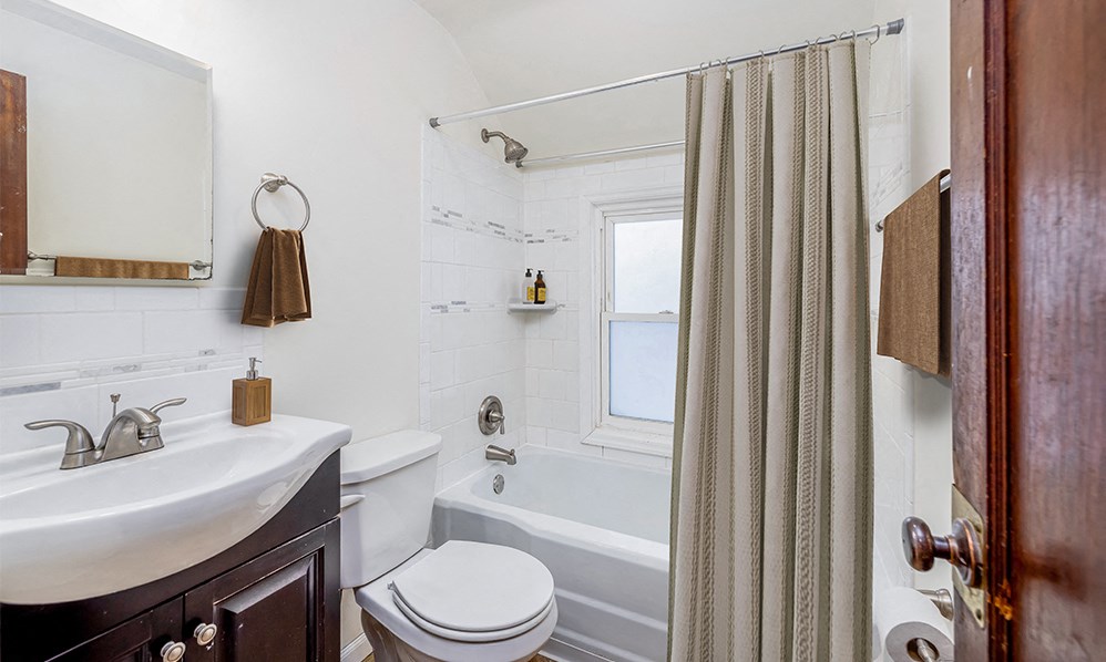 a bathroom with a sink toilet and tub and a shower curtain