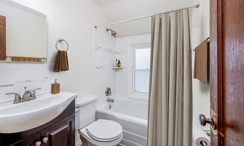 a bathroom with a sink toilet and tub and a shower curtain