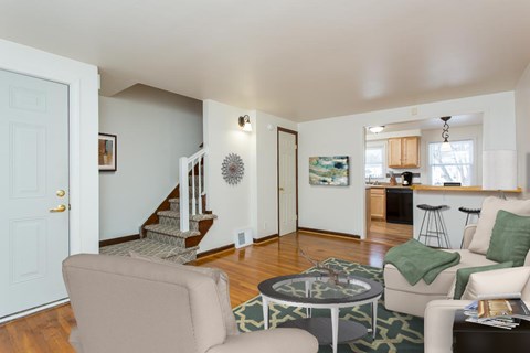 a living room with couches and chairs and a door to a kitchen