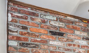 a kitchen with an exposed brick wall and a table with chairs