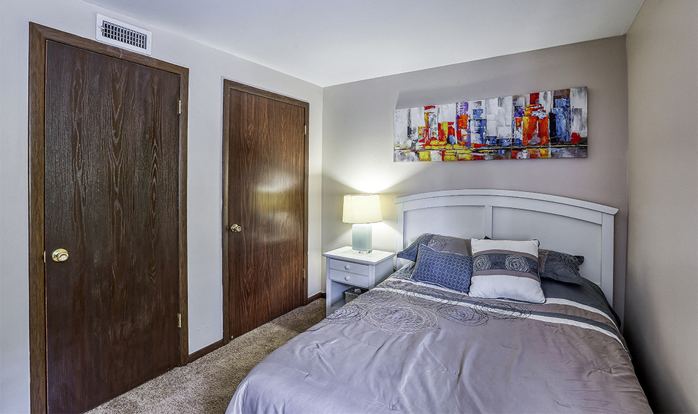 a bedroom with a bed and two closet doors