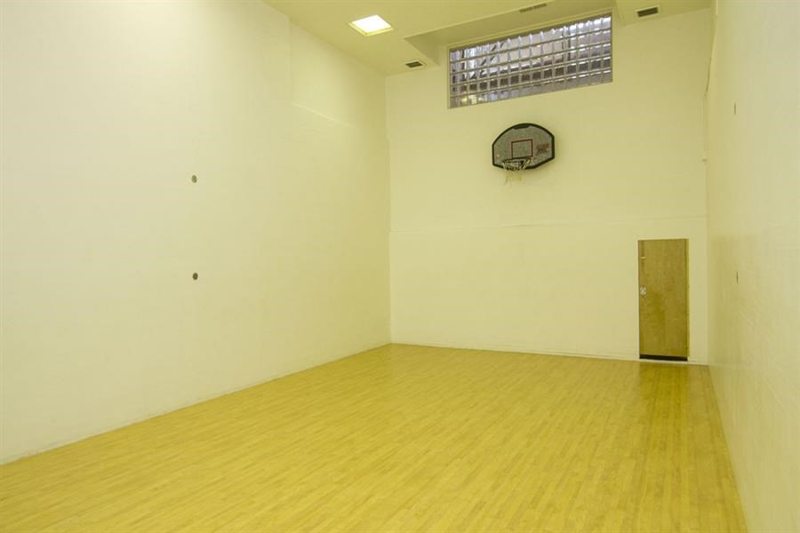an empty room with a clock on the wall and a wooden floor
