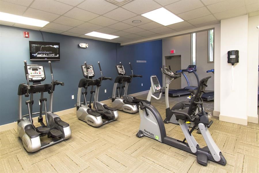 a gym with various exercise machines and a television