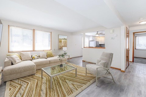 A living room with a glass coffee table and a beige sofa.