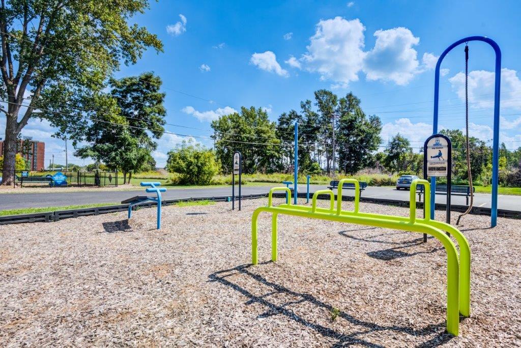 Outdoor fitness stations with signs instructing how to use each station