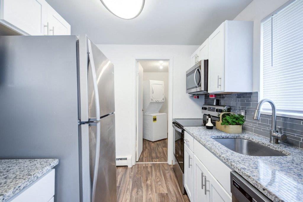 kitchen with white cabinets, granite counters, and stainless appliances
