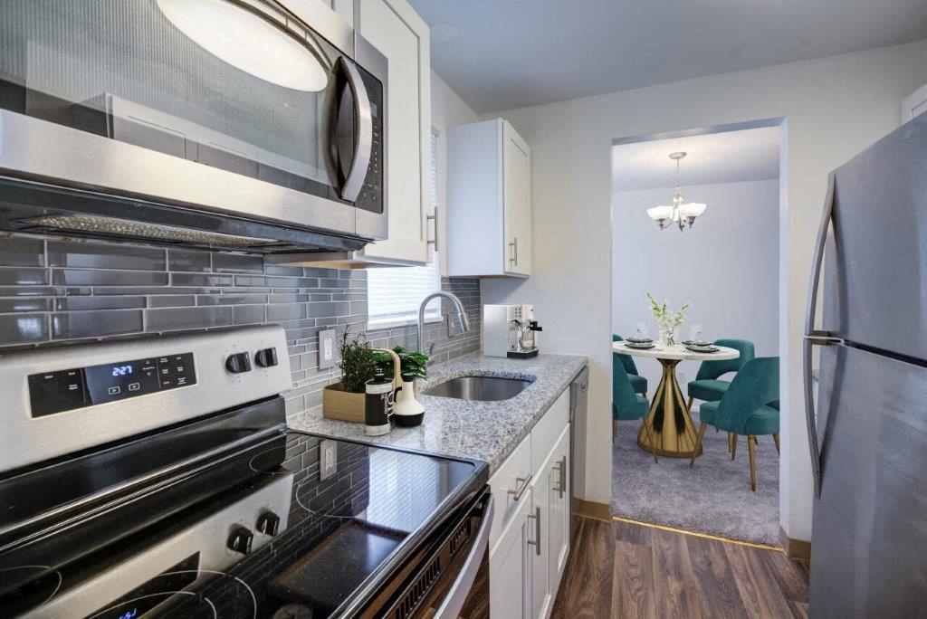 kitchen with white cabinets, granite counters, and stainless appliances
